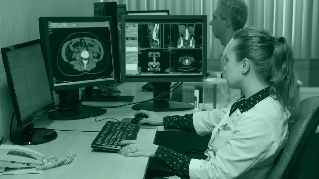 Radióloga revisando imágenes de tomografía en varios monitores