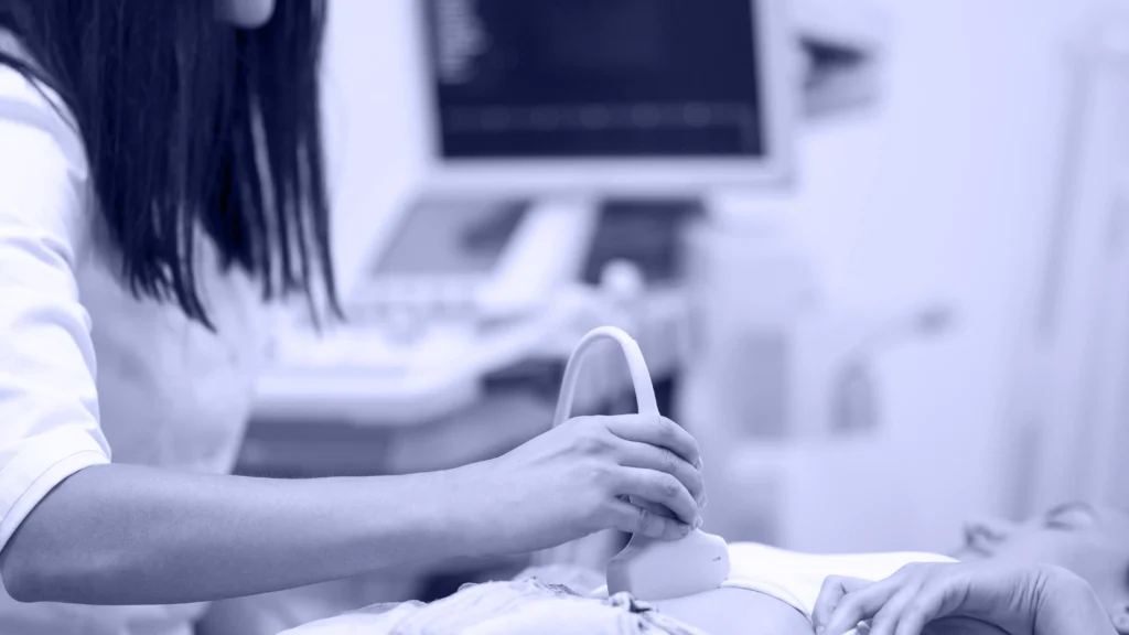 Profesional realizando una ecografía abdominal a una paciente