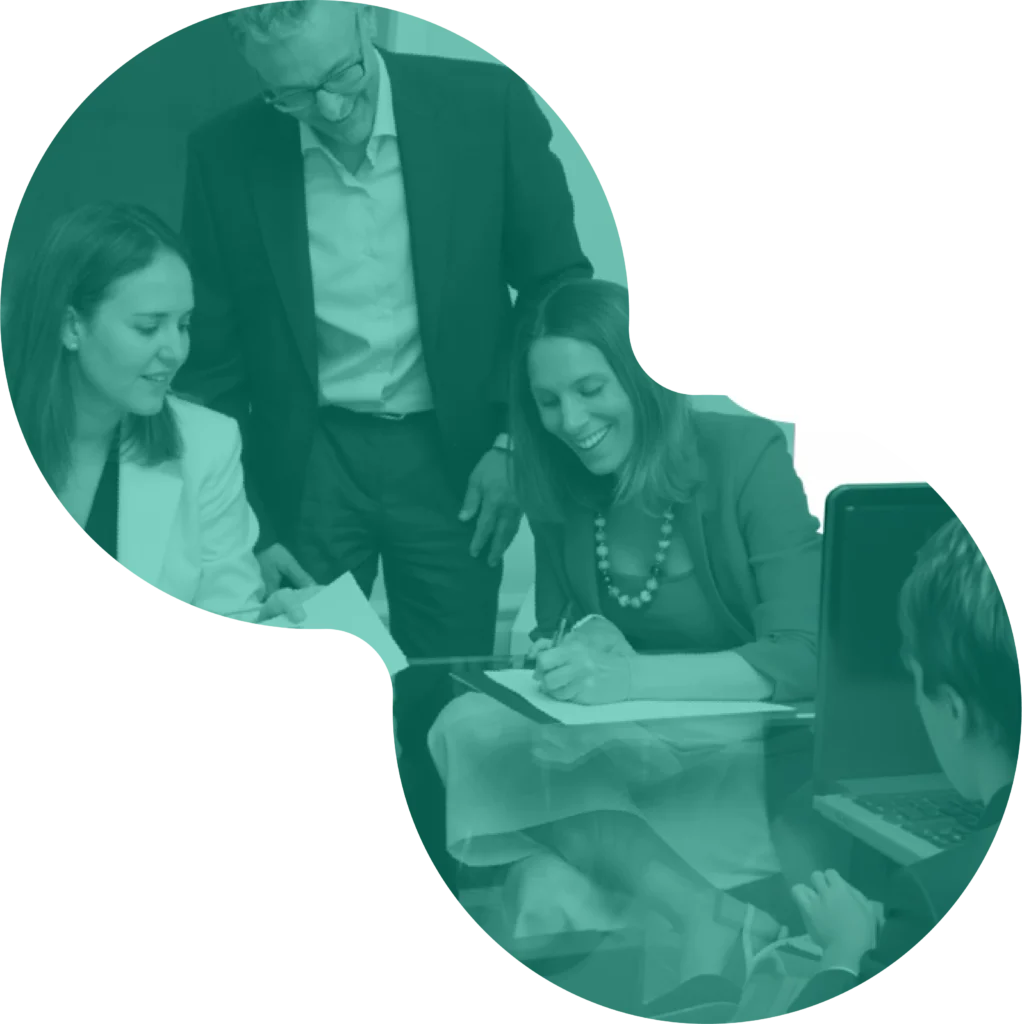 Equipo de trabajo revisando y firmando documentos junto a un notebook