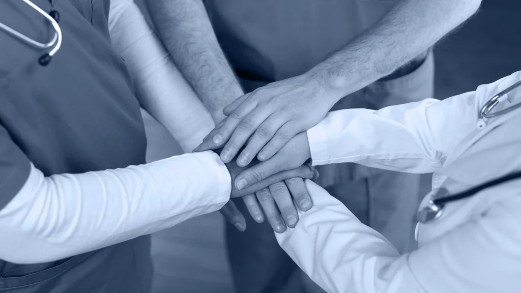Equipo de salud uniendo sus manos en señal de trabajo conjunto